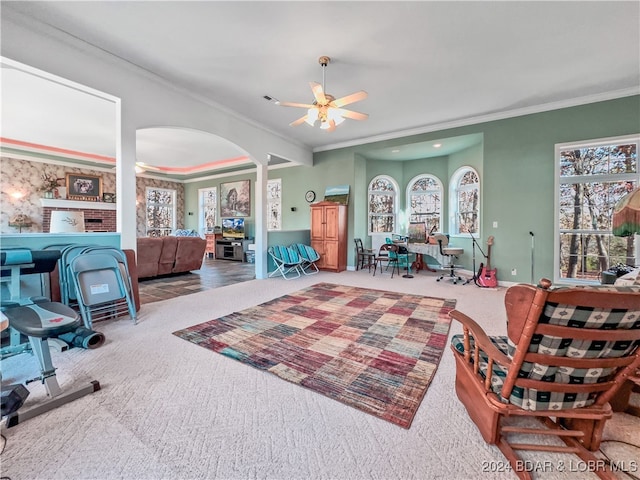 interior space with ornate columns, carpet floors, ceiling fan, and crown molding