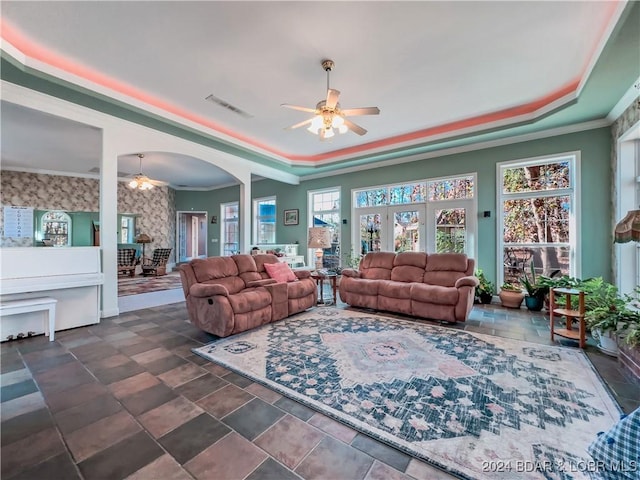 293 Windsong, Camdenton, MO 65020 - living room with ceiling fan, a tray ceiling, crown molding, stone finish flooring, and arched walkways