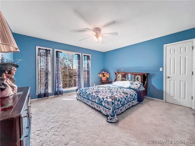 carpeted bedroom featuring baseboards and ceiling fan