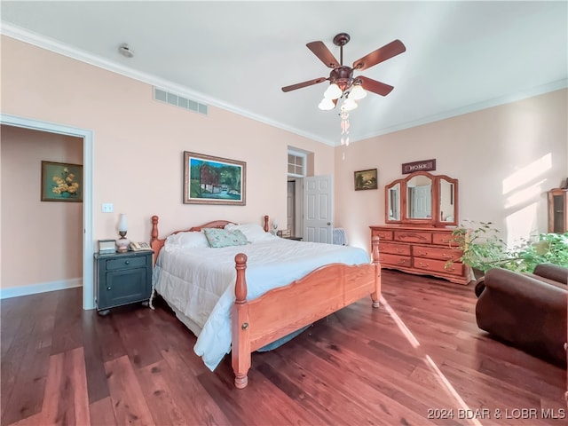 bedroom with dark wood-type flooring, ceiling fan, and ornamental molding