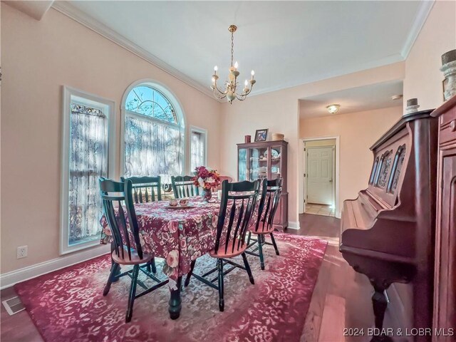 dining space with crown molding, a chandelier, baseboards, and dark wood-style floors