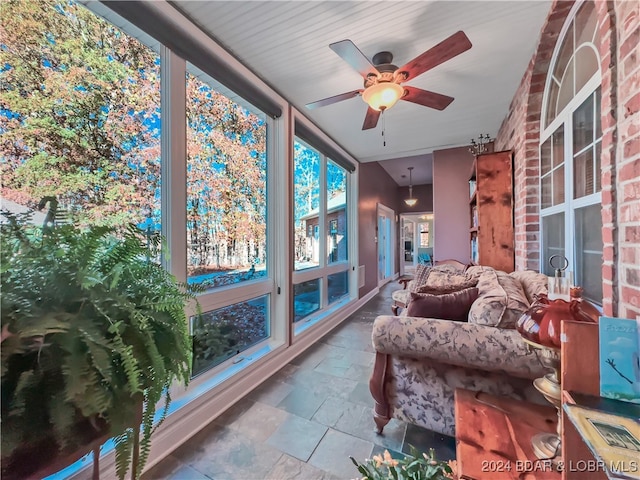 sunroom / solarium featuring ceiling fan