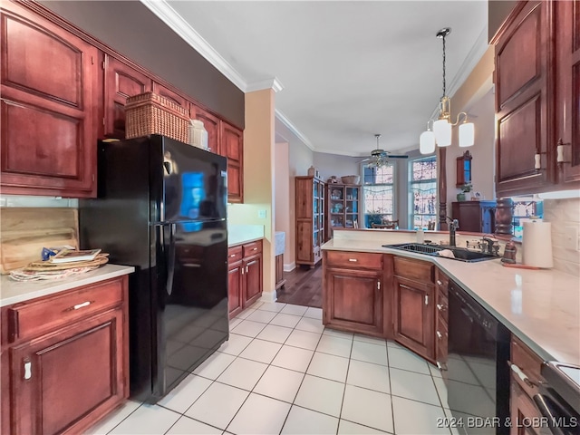 kitchen featuring kitchen peninsula, hanging light fixtures, black appliances, sink, and ornamental molding