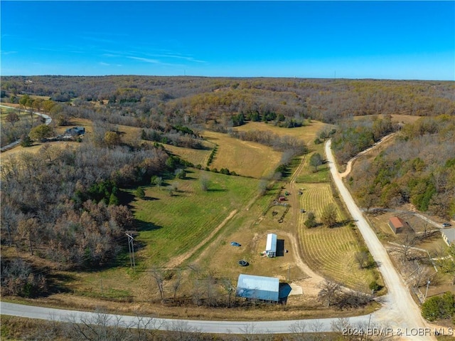 view of property location with rural landscape and a heavily wooded area