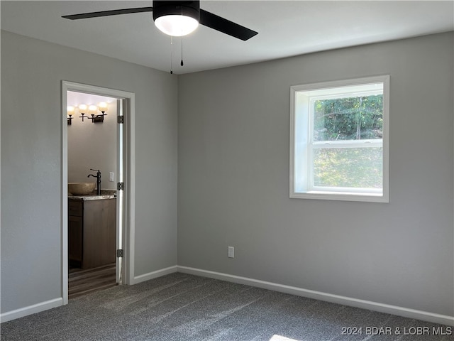 unfurnished bedroom with carpet, sink, ceiling fan, and ensuite bathroom