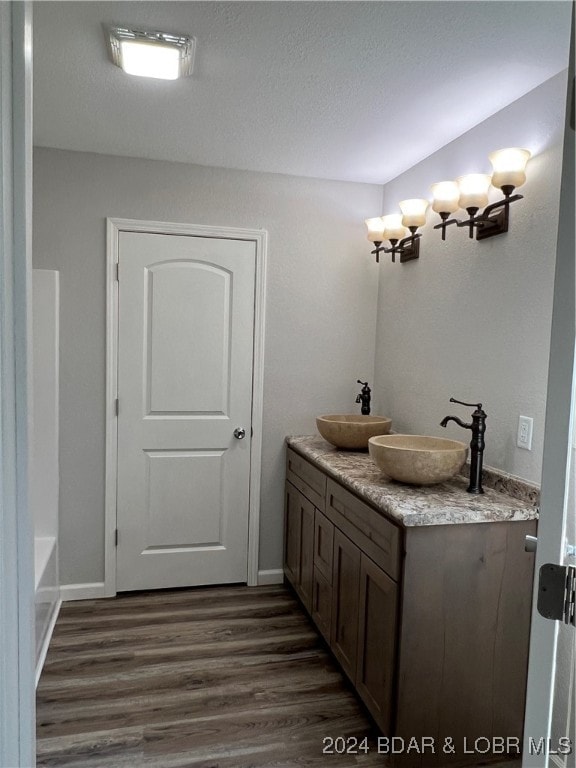 bathroom with vanity, wood-type flooring, and a textured ceiling