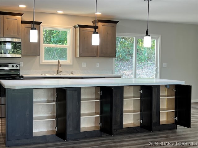 kitchen featuring stainless steel appliances, sink, a center island, pendant lighting, and dark hardwood / wood-style flooring