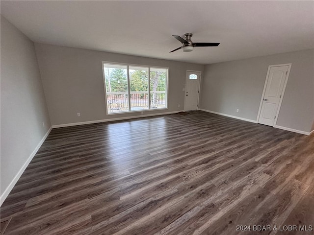 unfurnished room with dark wood-type flooring and ceiling fan