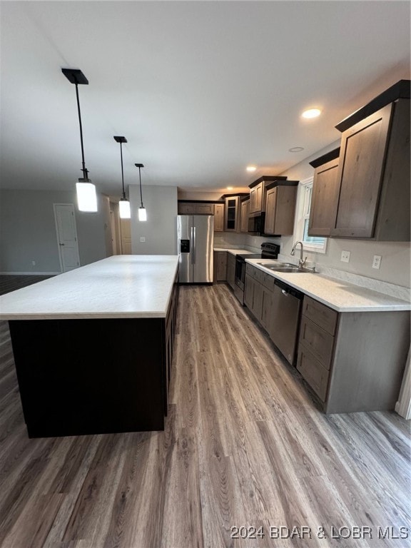 kitchen featuring appliances with stainless steel finishes, hanging light fixtures, dark hardwood / wood-style floors, and a center island