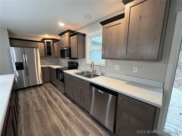 kitchen featuring dark brown cabinetry, stainless steel appliances, sink, and dark hardwood / wood-style floors