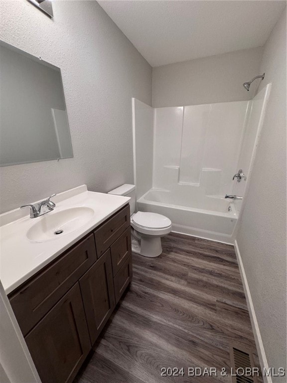 full bathroom with toilet, vanity, hardwood / wood-style flooring, and shower / bathing tub combination