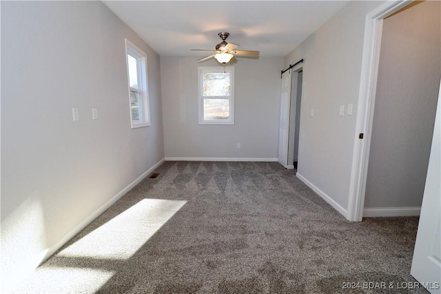 261 Buffalo Linn Creek Rd, Macks Creek, MO 65786 - unfurnished bedroom with carpet flooring, a barn door, and ceiling fan
