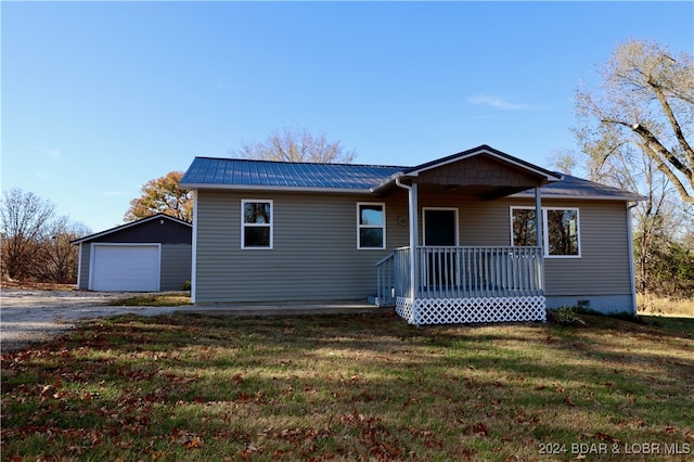 view of front of property featuring a garage, a front lawn, and an outdoor structure