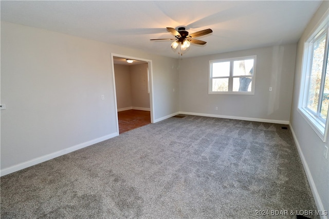 carpeted spare room with ceiling fan