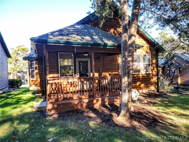 rear view of house featuring a yard