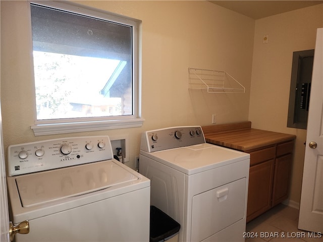 laundry area with electric panel, cabinets, light tile patterned floors, and washer and dryer