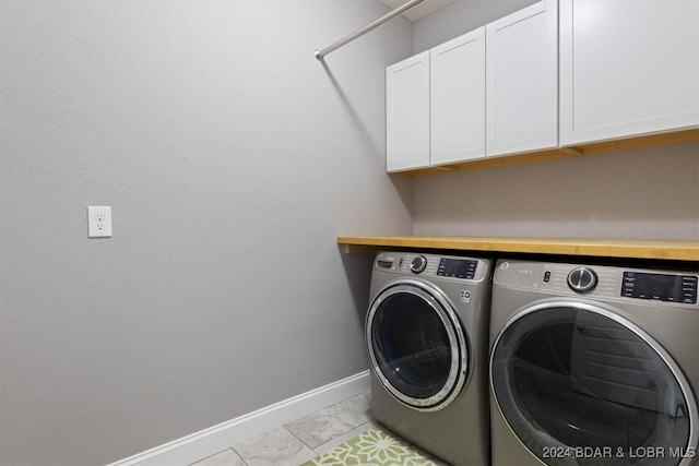 clothes washing area with separate washer and dryer, cabinets, and light tile patterned flooring