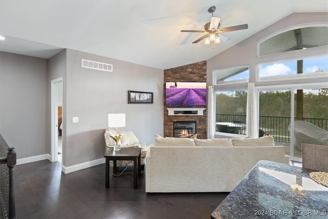 living room with dark wood-type flooring, ceiling fan, a fireplace, and lofted ceiling