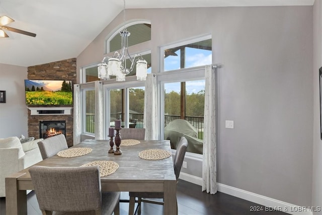 dining area with lofted ceiling, ceiling fan with notable chandelier, dark hardwood / wood-style floors, and a fireplace