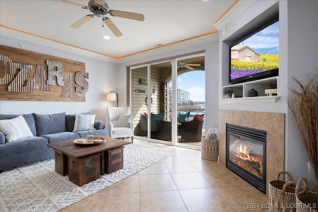 tiled living room with a fireplace, ceiling fan, a healthy amount of sunlight, and ornamental molding