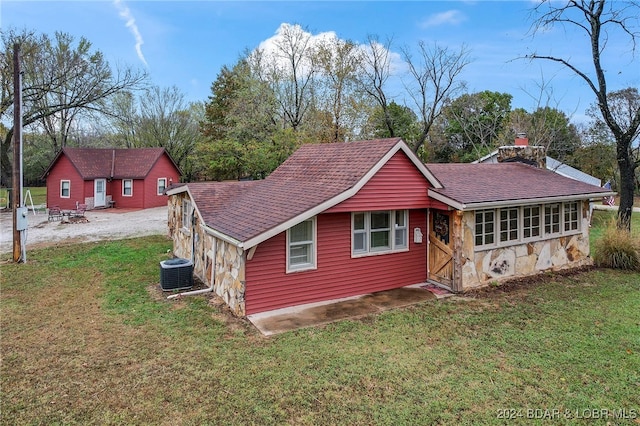 rear view of house with a lawn and central AC