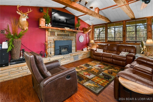 living room featuring a wood stove, lofted ceiling with beams, and hardwood / wood-style floors