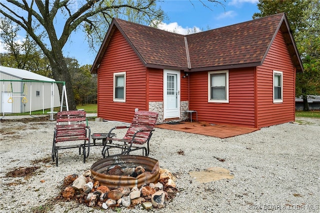 rear view of property with an outdoor fire pit and a patio area