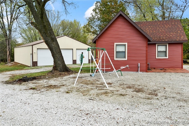 back of house featuring a garage and an outdoor structure