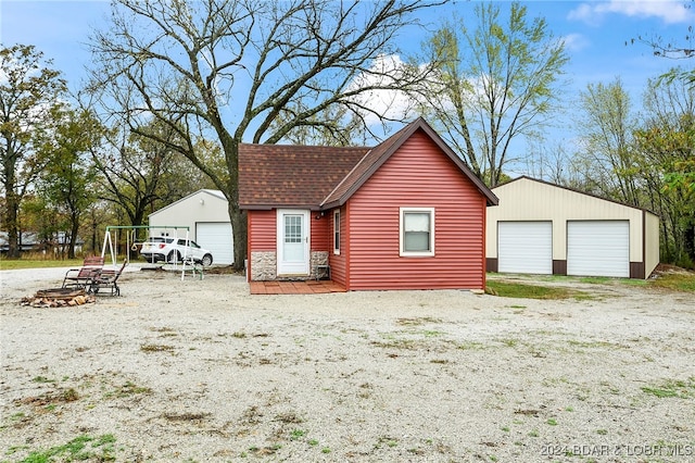 exterior space featuring a garage and an outbuilding