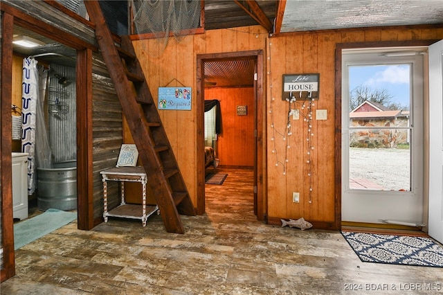 interior space featuring wood walls, beamed ceiling, and a wealth of natural light