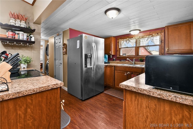 kitchen with dark wood-type flooring, wood ceiling, sink, stacked washer and dryer, and stainless steel fridge