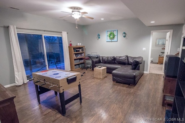 living room featuring dark hardwood / wood-style flooring and ceiling fan