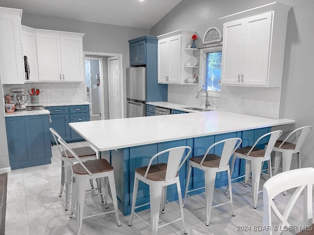 kitchen with blue cabinetry, decorative backsplash, and white cabinets