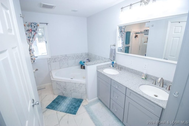 bathroom featuring vanity and a relaxing tiled tub