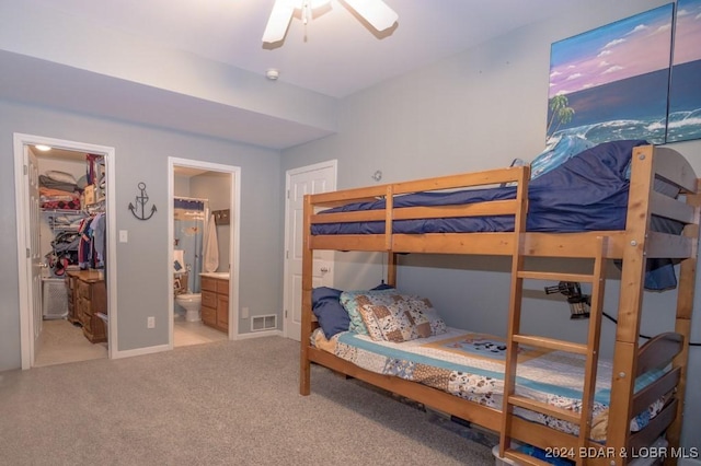 bedroom with ensuite bathroom, ceiling fan, a spacious closet, carpet floors, and a closet