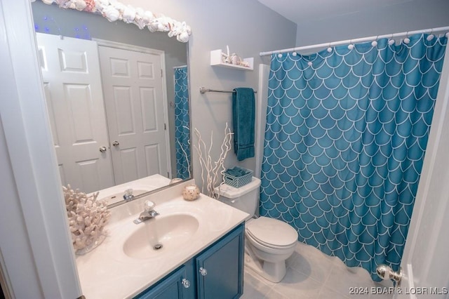 bathroom with tile patterned floors, toilet, vanity, and walk in shower