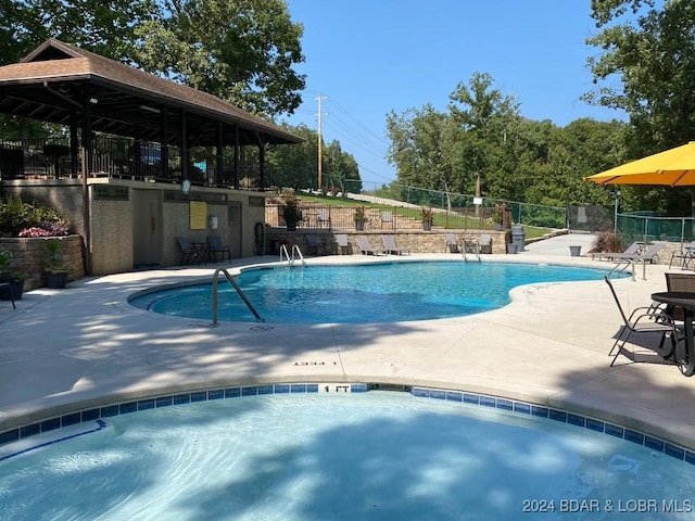 view of swimming pool with a patio and a hot tub