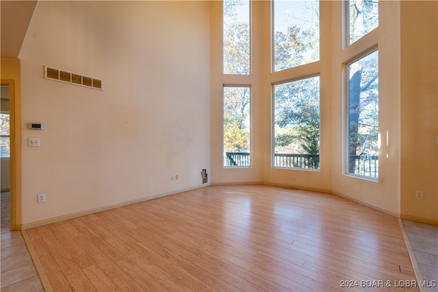 unfurnished room with light hardwood / wood-style floors and a high ceiling