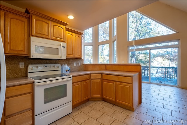 kitchen with decorative backsplash, a wealth of natural light, and white appliances