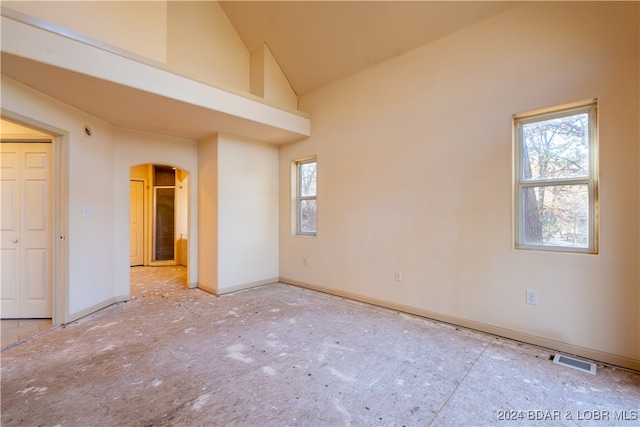 spare room with high vaulted ceiling and a wealth of natural light