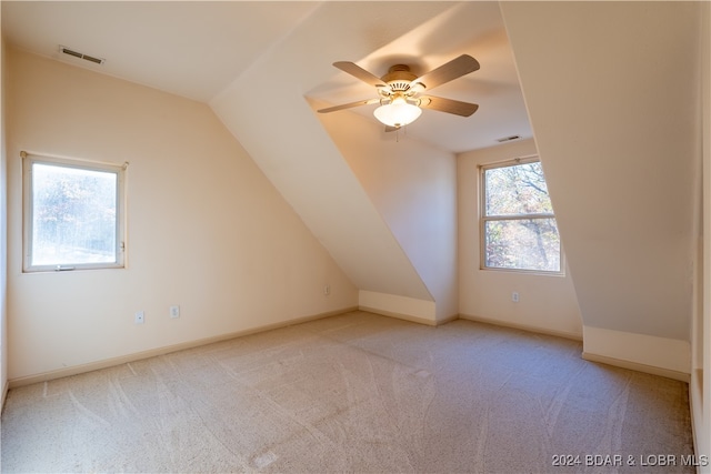 additional living space featuring light colored carpet, lofted ceiling, and ceiling fan