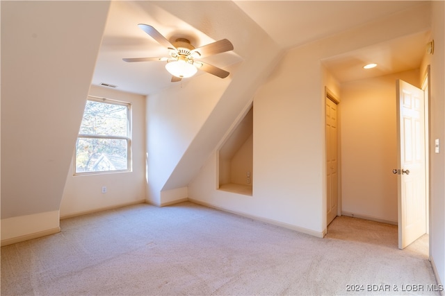 additional living space with vaulted ceiling, light colored carpet, and ceiling fan