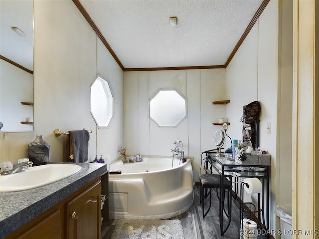 bathroom with crown molding, a textured ceiling, vanity, a tub, and hardwood / wood-style floors