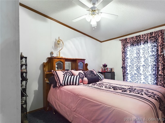 carpeted bedroom featuring ornamental molding, a textured ceiling, and a ceiling fan