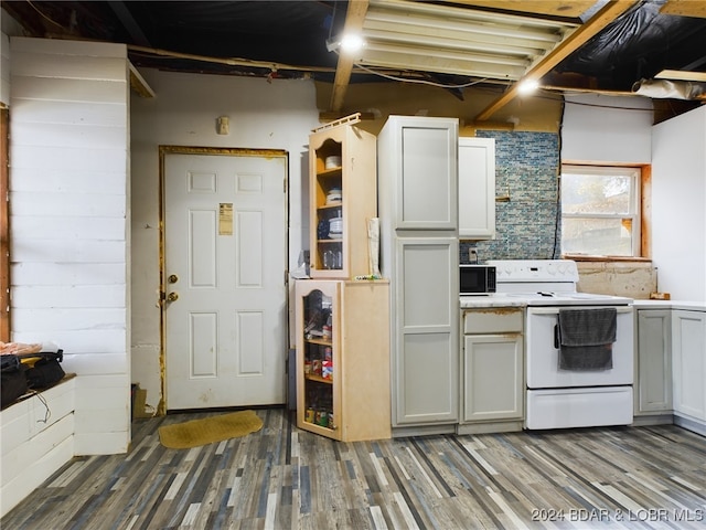 kitchen with dark wood-style floors, white range with electric stovetop, light countertops, and white cabinetry