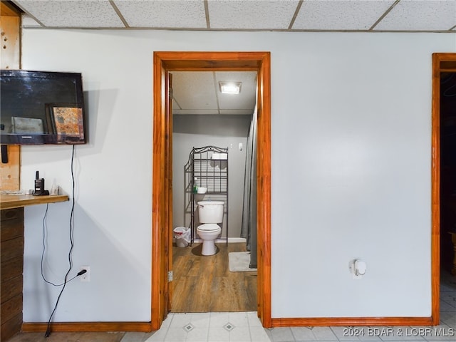 bathroom with a paneled ceiling, baseboards, and toilet