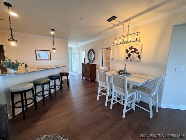 dining space with ornamental molding and dark hardwood / wood-style floors