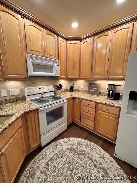 kitchen featuring white appliances, tasteful backsplash, light stone counters, and dark hardwood / wood-style floors