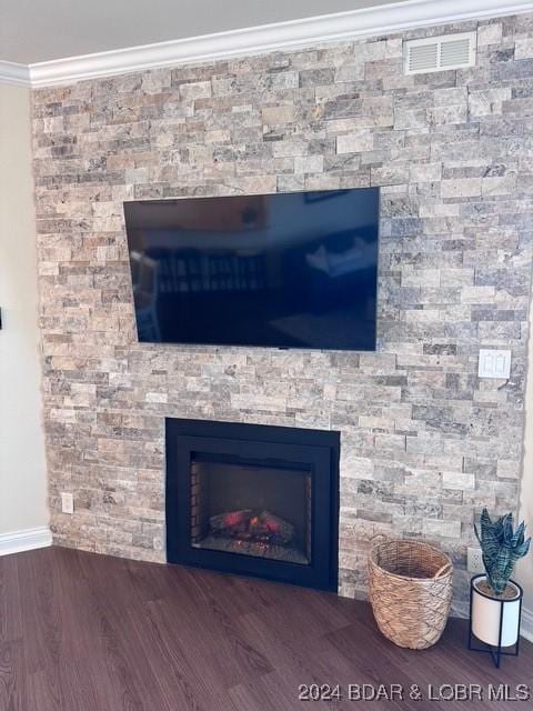 interior details featuring a fireplace, crown molding, and hardwood / wood-style flooring