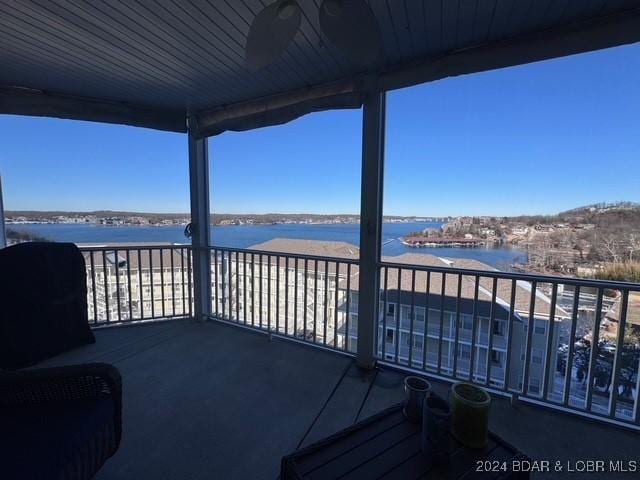 deck featuring ceiling fan and a water view